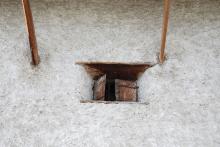 Travi di legno inserite nel muro sopra le finestre del piano terra, a sostegno del piano residenziale sovrastante
