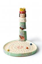 Colourful painted wooden marble game consisting of a plate with 90 dents and a figurine at the edge hollowed out like a helter-skelter